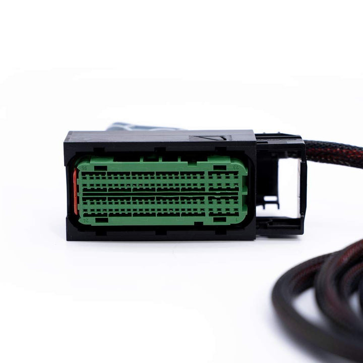 Close-up of a car wiring connector with green connector on a white background