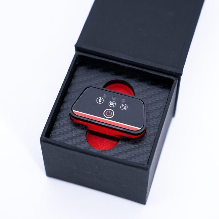 Black and red electronic device in an open black box on a white background