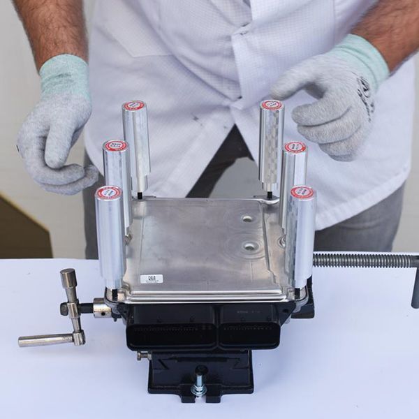 Technician using BOSCH ECU opener tool with MAGBench for secure disassembly of control units


